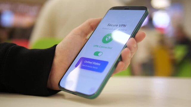 Simple, clear shot of a user enabling a VPN connection with a single tap before going online in a shared space. This clip symbolizes taking charge of ones digital footprint, encrypting data, and safe