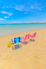 foto de cadeiras de praia de crian&ccedil;a de frente para mar calmo num dia de ver&atilde;o.
