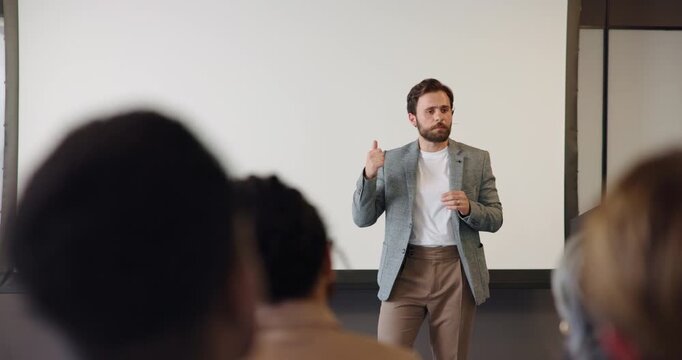 Speaker, man and discussion with audience in seminar for industry trends, information and feedback. Global event, crowd and coach with speech in conference for career development, learning or upskill