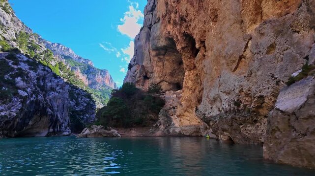 Boat trip on turquoise water of mountain canyon, Verdon Gorge in french Alps, Provence France. Near Aiguines. Canyon is about 25 kilometres long and up to 700 metres deep.