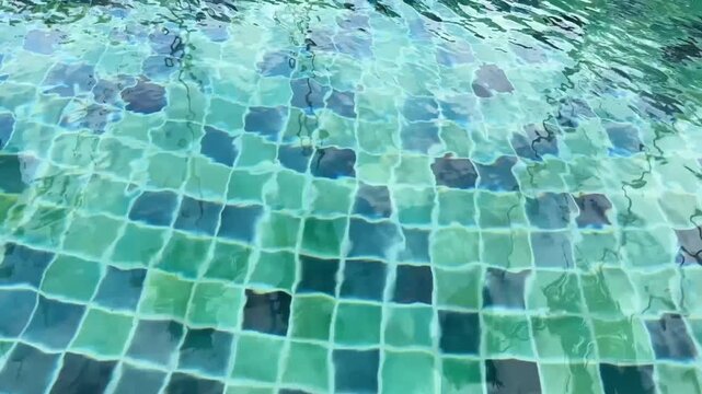 video of vibrant pool water moving across blue green tiles with gentle shifting light reflections
