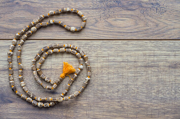 Japa Mala Beads Spiraling on a Wooden Table for Meditation and Yoga