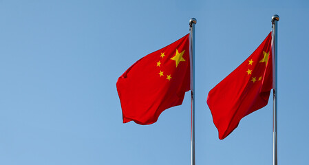 Two flags of China on flagpole and blue sky