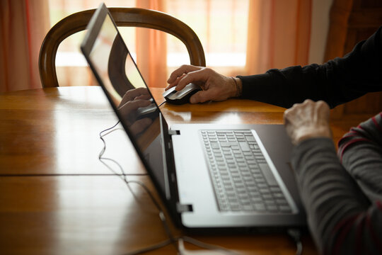 Un couple de seniors consulte leur ordinateur portable dans le salon