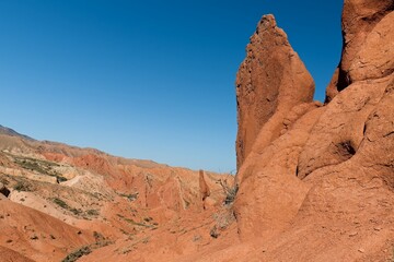 Fototapeta premium Fairytale Canyon (Canyon Skazka) was formed by the erosion of multi-colored clays, rocks and minerals. It is located near the southern shore of Issyk Kul Lake in Kyrgyzstan. Asia.