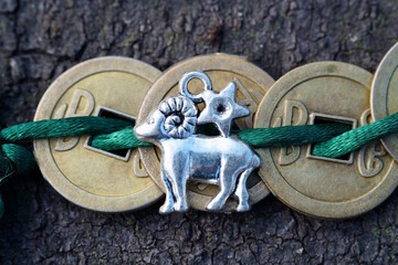 Chinese coins and aries figurine in close-up. Finance and horoscope.