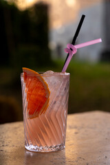 cocktail in a glass with a straw on a stone table.