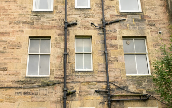 Drainpipes and windows outside old tenement building, in the Victorian suburb of Morningside, Edinburgh, Scotland, UK