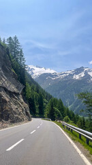 Winding Mountain Road Through Alpine Scenery, Alpine Road Leading to Majestic Snow-Capped Mountains