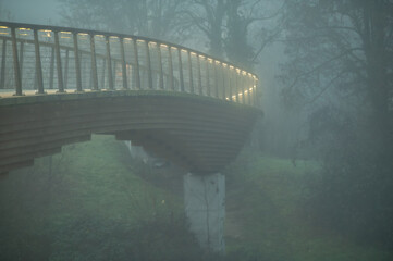 Untersicht Holzbr&uuml;cke Radwegbr&uuml;cke auf Betonpfeiler mit Beleuchtung am Gel&auml;nder im Nebel in  Neckartenzlingen