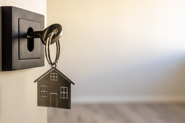 Open door to a new home. Door handle with key and home shaped keychain. Mortgage, investment, real...