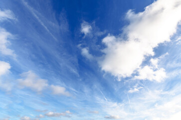 Vast blue sky with wispy cirrus and cumulus clouds on a bright sunny day