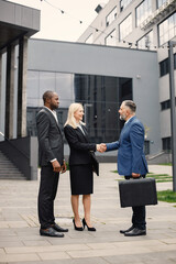 Business people standing and talk to each other in front of modern office