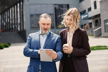 Business people standing and talk to each other in front of modern office