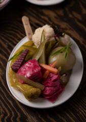 Pickled vegetables in a plate on a wooden table.