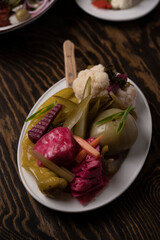 Pickled vegetables in a plate on a wooden table.