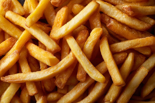 Golden French fries forming a full textured potato background.