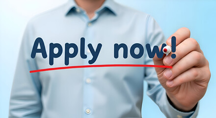 Businessman writing the urgent call to action apply now with a red line underneath on a transparent surface against a light blue background for recruitment marketing