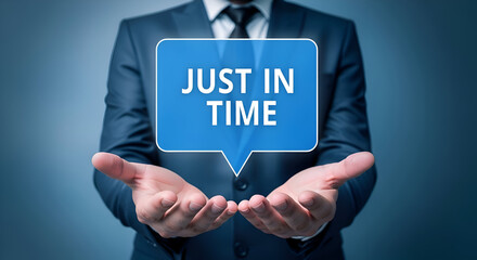Businessman presenting the concept of just in time inventory management strategy using a floating blue speech bubble against a dark blue background for logistics