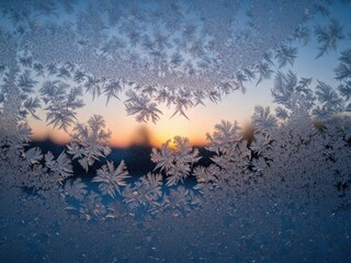 Close up of ice flowers on a window with sun in the background