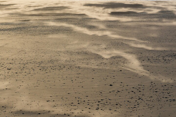 Wind blown sand moving across the beach