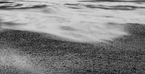 Wind blown sand on a beach in black and white