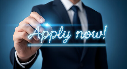 Businessman in a dark suit draws glowing neon blue text that reads apply now with an underline on a digital interface against a dark blue background symbolizing immediate action and opportunity