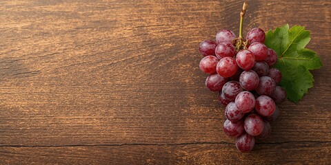 Fototapeta premium Cluster of grapes placed on rustic wood, ideal for culinary or wine-related layouts