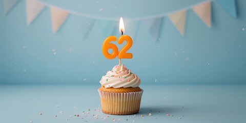Orange candle number 62, birthday cupcake on blue background, celebrating milestone age