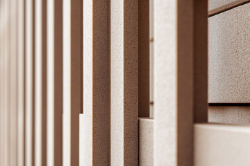 Close-up of modular fence panels in a sand color, highlighting geometric patterns and panel joints. This design creates a modern and stylish outdoor boundary