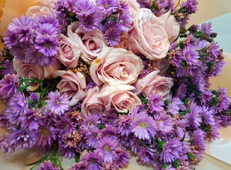 Close-up photo of beautiful flower bouquet of pink roses and purple chrysanthemum.