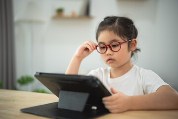 Young Girl Using Tablet for Learning in Bright Room Home Setting