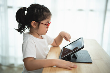 Young Child Engaged with Tablet Device at Home with Focused Expression
