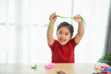 Happy Child Playing with Colorful Modeling Clay at a Bright Table