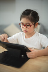 Young Girl Engaged in Tablet Activity at Home with Focused Expression