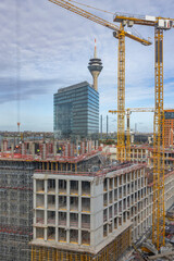 Bauarbeiter arbeiten auf einer Gro&szlig;baustelle an einem B&uuml;rogeb&auml;ude
