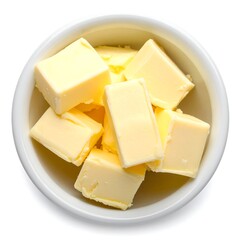 A close-up, top-down view captures a white bowl overflowing with meticulously cubed, golden-yellow dairy product. A pristine white backdrop highlights the subject