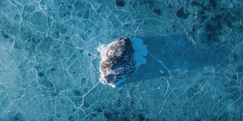 Aerial view of ice fissures and Shaman Rock on Lake Baikal, seasonal freeze and thaw patterns