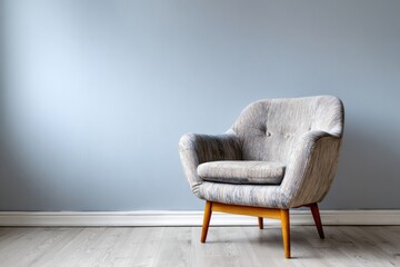 Vintage armchair sits by a light blue wall on a wooden floor.