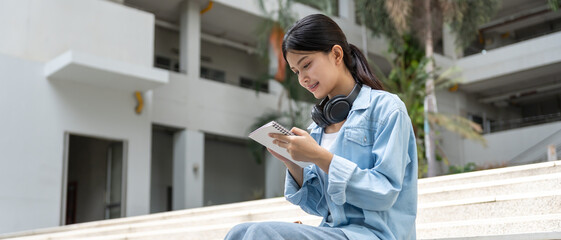 Portrait beautiful Asian woman student. Smile girl happy study. Write note in college campus. young female on international Asia University. Education, study, school, learning, exam