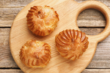 Tasty profiteroles on wooden table, top view