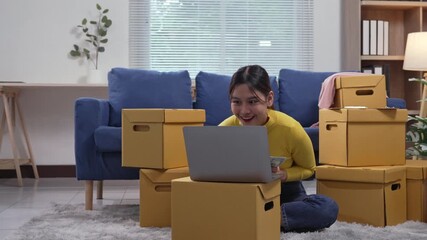 Young Asian woman feeling happy and celebrating after checking orders on her laptop, counting money and throwing it in the air with joy - Powered by Adobe