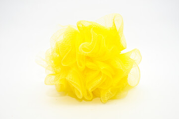 Close-up of a large, bright neon yellow mesh bath loofah, sponge, isolated on a clean white background. Essential tool for shower hygiene, spa treatment, body care, and relaxation concept.