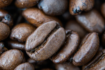 Macro close-up of roasted coffee beans with rich brown texture.