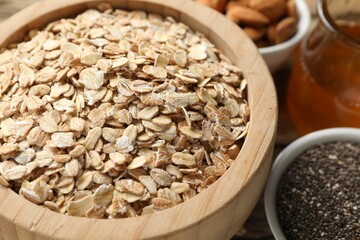 Making granola. Oat flakes in bowl and chia seeds on table, closeup