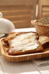 Bread slices with butter on white wooden table, closeup. Space for text