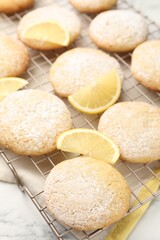 Tasty lemon cookies and fruit slices on white marble table, closeup