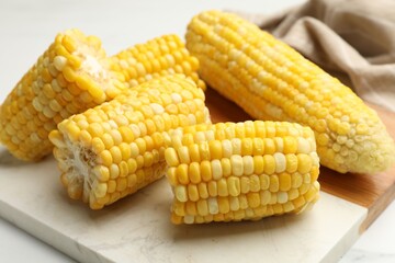 Pieces of boiled corncobs on white table, closeup