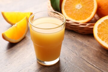 Fresh orange juice and fruits on wooden table, closeup
