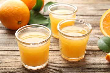 Fresh orange juice and fruits on wooden table, closeup